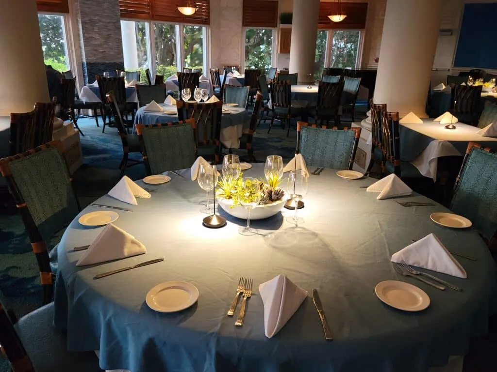 A dining room with a round table set for multiple people