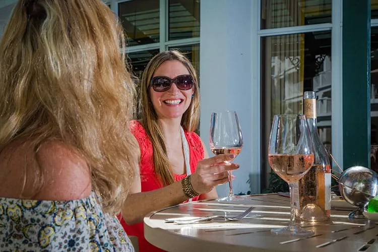 Two women sitting at a table with wine glasses and a bottle