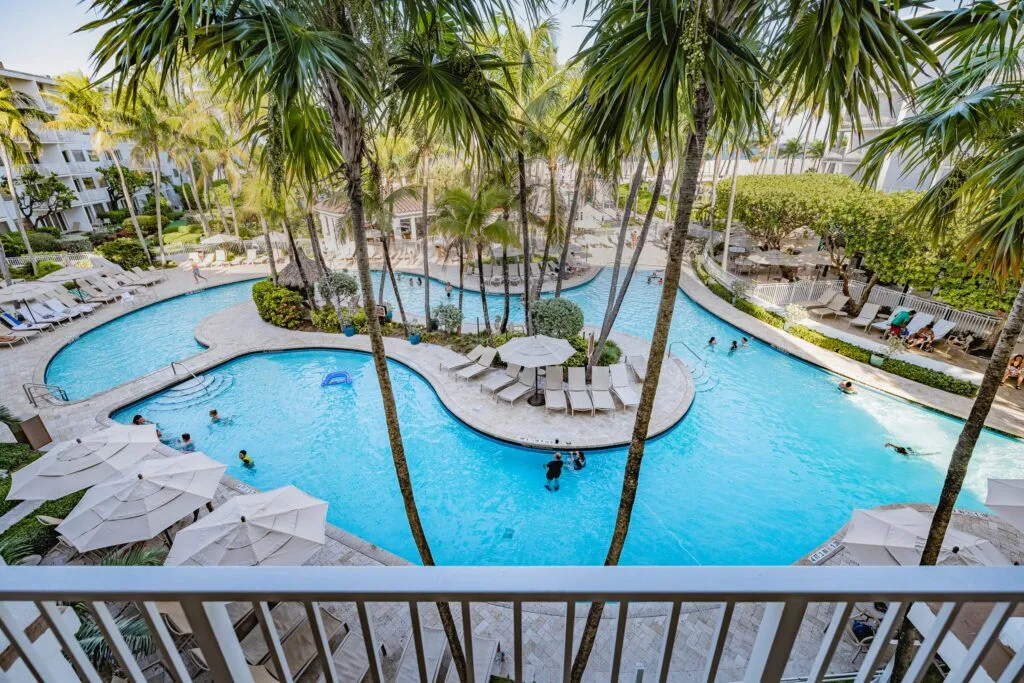 A large pool with lounge chairs and palm trees